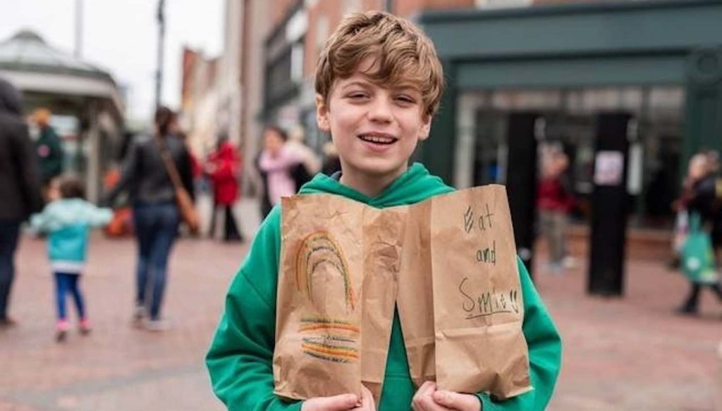 White kid gives food to homeless people.
